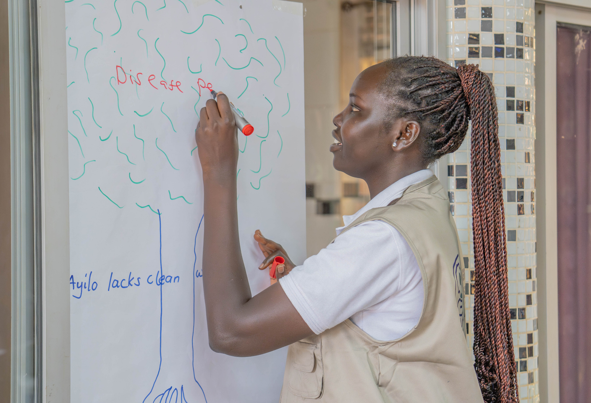 Facilitator mapping disease and water challenges during a Tuku Tuku Innovation Labs problem-framing session