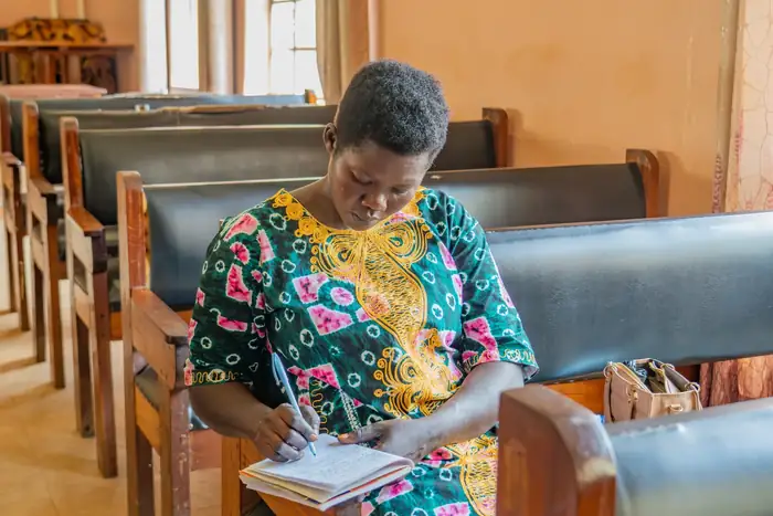 Programme participant taking notes during a field data session